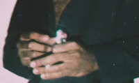a man in a suit holding a cigarette